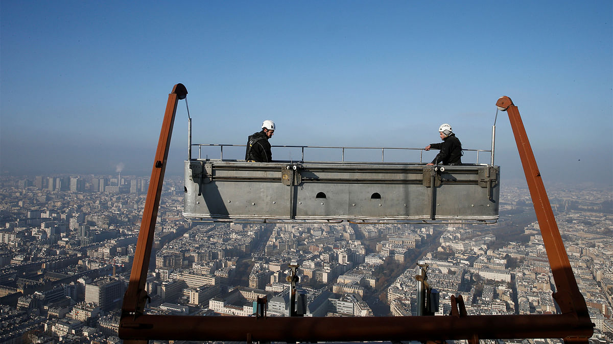 A small-particle haze hangs above the skyline as workers clean the windows of the Montparnasse tower in Paris, France, December 29, 2016. Photo: Reuters