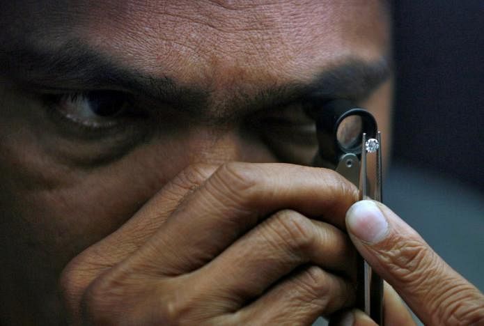 A supervisor checks the shape of a polished diamond inside the diamond processing unit at Surat, in the western Indian state of Gujarat 5 January, 2013. Reuters file photo