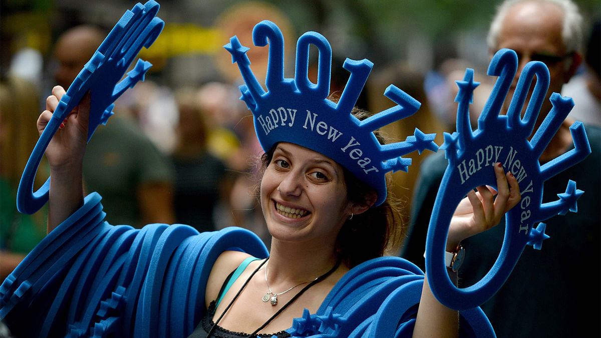 A woman sells `Happy New Year 2017` headwear on a shopping street in Sydney on December 30, 2016. Photo: AFP