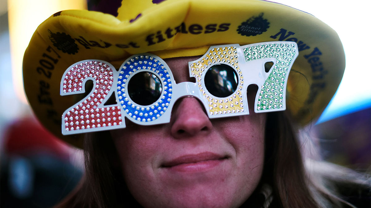 A reveler poses for a photo as she wears glasses that read `2017` in during New Year`s Eve festivities in the Times Square area of New York, December 31, 2016. Reuters