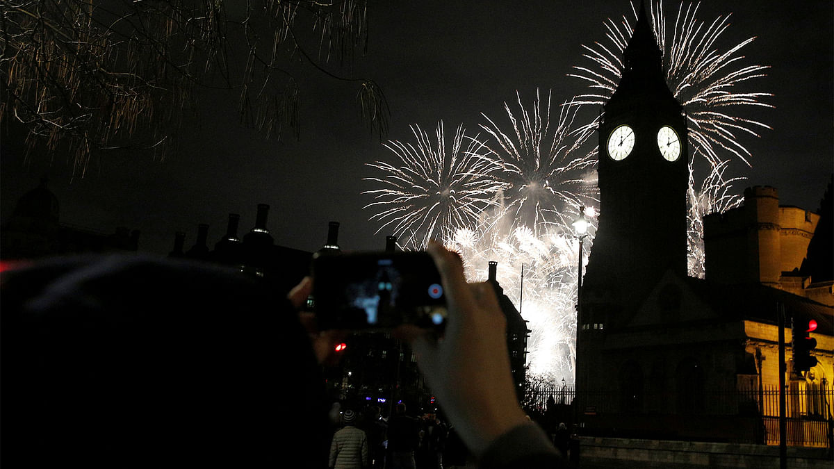 A man photographs fireworks as they explode by the Big Ben clocktower in London, Britain January 1, 2017. Reuters