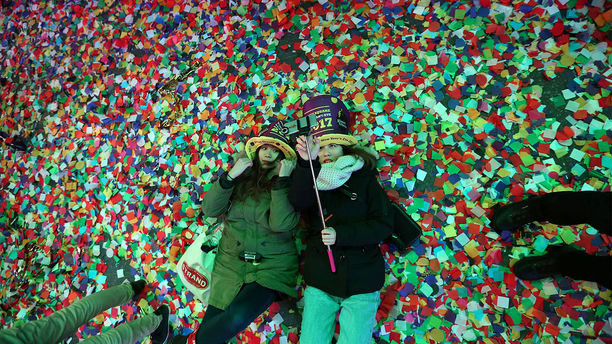 Revelers play in the confetti at the start of 2017 at the New Year`s celebration in Times Square in Manhattan. Reuters