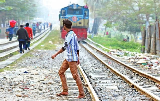 A pedestrian is crossing railroad risking life at Tejgaon rail crossing. Photo: Ashraful Alam