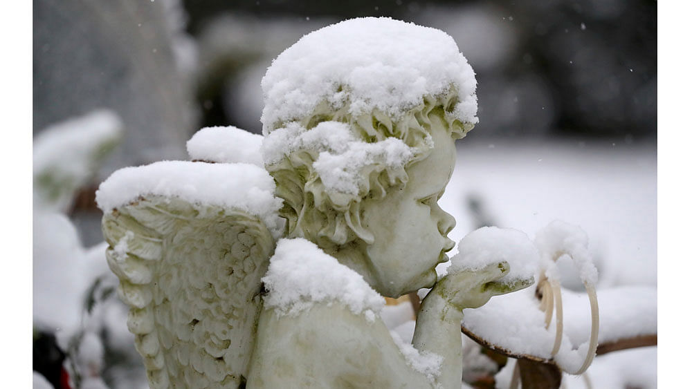 A snow covered angel statue is pictured at the main cemetery in Hanau, near Frankfurt, Germany. Reuters