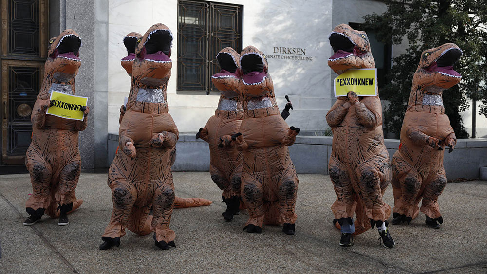 Activists dressed as dinosaurs rally against former ExxonMobil CEO and Secretary of State nominee Rex Tillerson outside Dirksen Senate Office Building on January 11, 2017 in Washington, DC. AFP