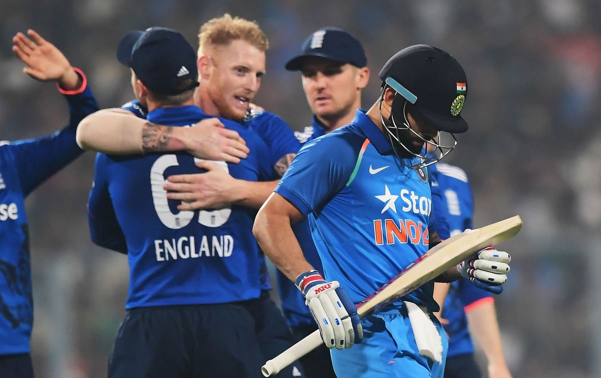 India's captain Virat Kohli (R) reacts after losing his wicket as England's Ben Stokes(C) celebrates with teammates during the third One Day International match between India and England at the Eden Gardens Cricket Stadium in Kolkata on 22 January, 2017. Photo: AFP