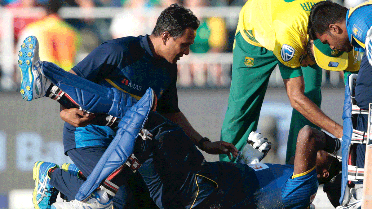 Sri Lanka batsman and captain Angelo Mathews (bottom) is treated by medical personnel after getting injured while taking a run during the second T20 match between South Africa and Sri Lanka. Photo: AFP