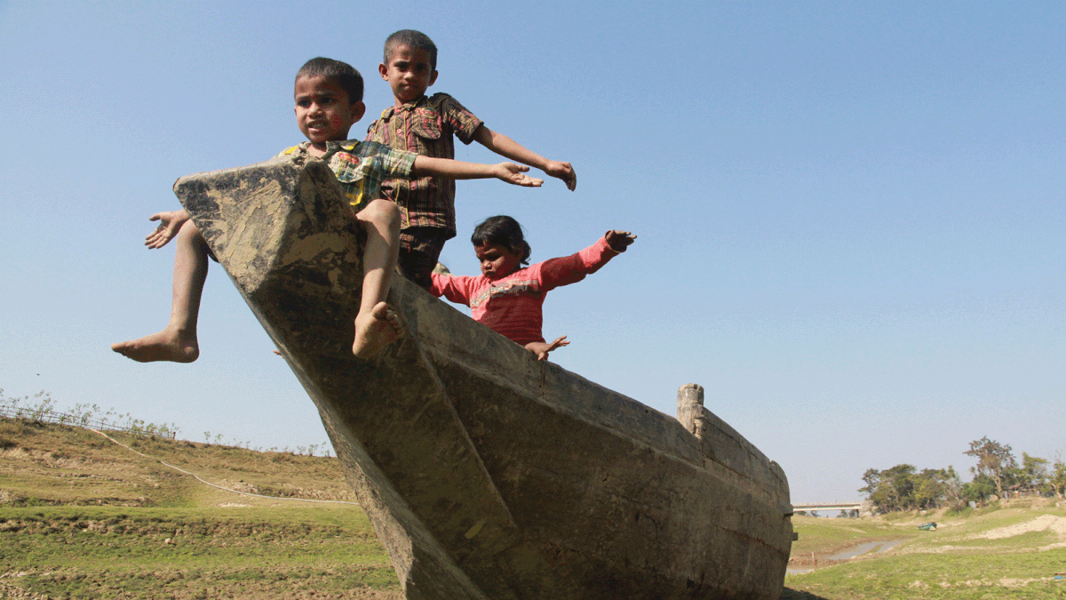 Children playing on a boat as it got stuck in Putimara Khal in Sylhet Sadar on Tuesday. Photo: Anis Mahmud