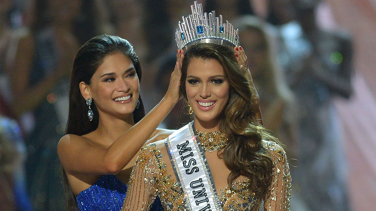 Miss Universe contestant Iris Mittenaere (R) of France is crowned the new 2017 winner by former Miss Universe Pia Wurtzbach of the Philippines (L) during the Miss Universe pageant at the Mall of Asia Arena in Manila on January 30, 2017. AFP