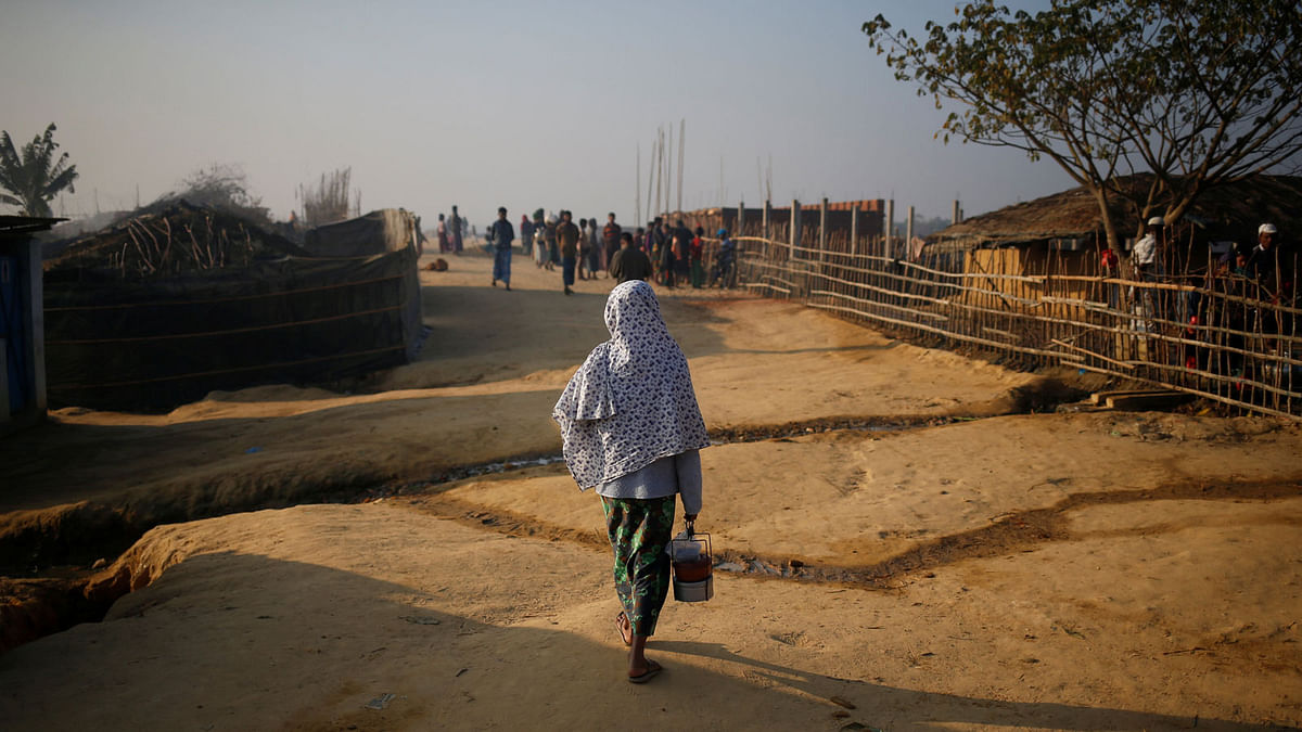 A Rohingya refugee walks on with a tiffin carrier in the morning at Kutupalang Unregistered Refugee Camp, in Cox`s Bazar, Bangladesh, February 4, 2017. Reuters