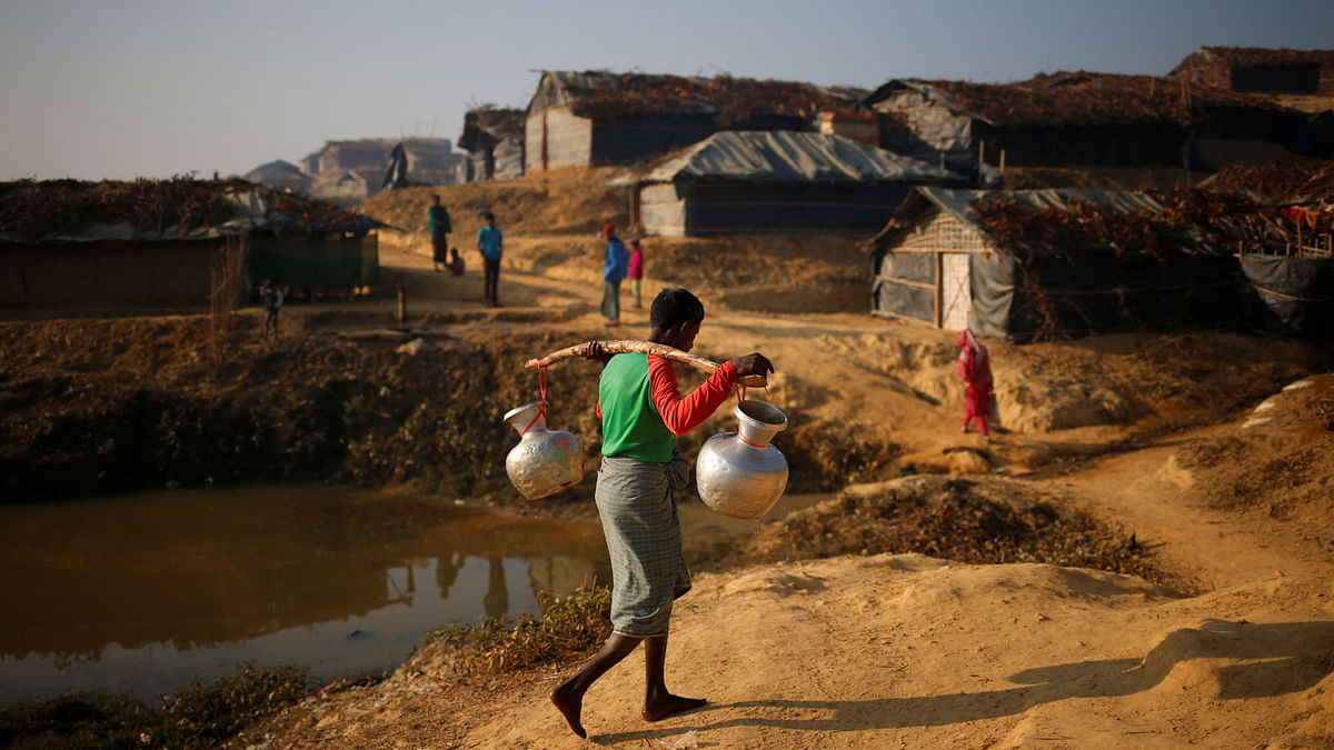 A Rohingya refugee man carries water on his shoulder in the morning at Kutupalang Unregistered Refugee Camp, in Cox`s Bazar, Bangladesh, February 4, 2017. Reuters
