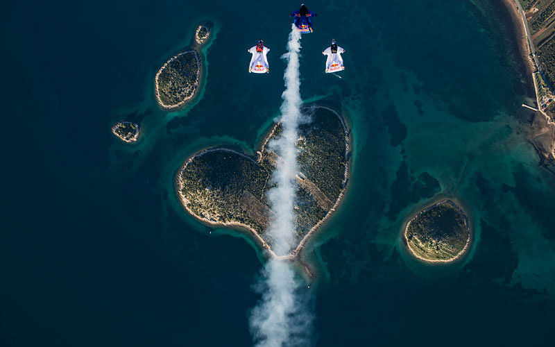 Marco Waltenspiel, Amy Chmelecki and Marco Fuerst fly their wingsuits over the heart island near Zadar, Croatia, November 30, 2016. Photo: Reuters