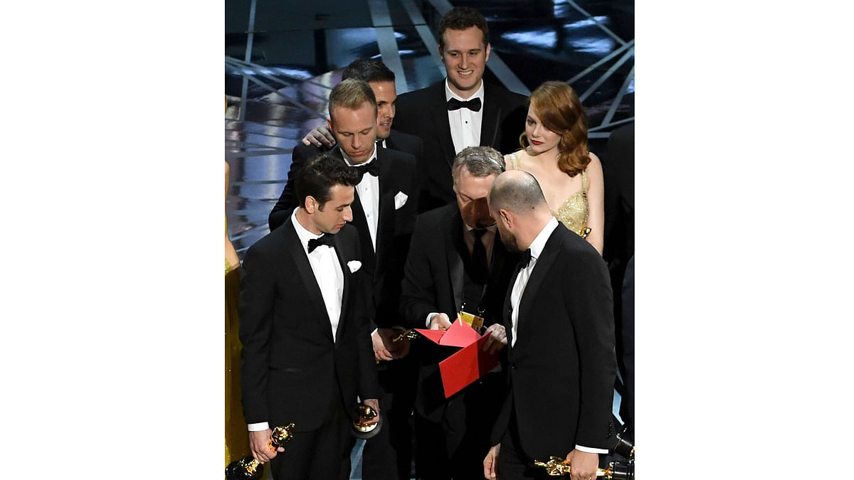 `La La Land` producer Jordan Horowitz (R) consults with production staffer regarding a presentation error of the Best Picture award (later awarded to `Moonlight`), as composers Justin Hurwitz and actor Emma Stone look on onstage during the 89th Annual Academy Awards at Hollywood & Highland Center on February 26, 2017 in Hollywood, California. Photo: AFP