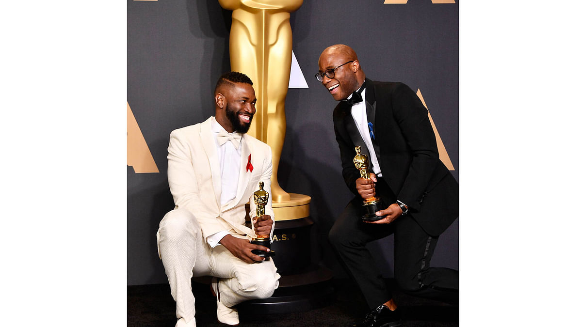 Screenwriter Tarell Alvin McCraney (L) and writer/director Barry Jenkins, winners of Best Adapted Screenplay for `Moonlight`, pose in the press room during the 89th Annual Academy Awards at Hollywood & Highland Center on February 26, 2017 in Hollywood, California. Photo: AFP