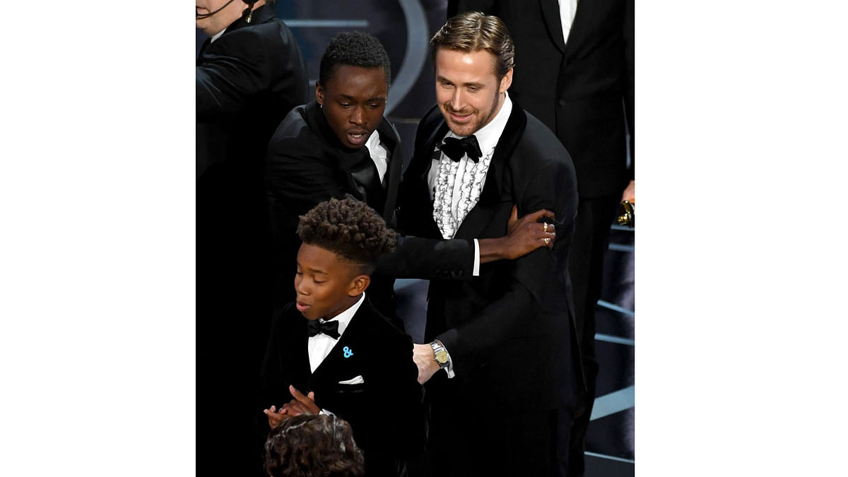 Actor Ryan Gosling (R) congratulates actors Ashton Sanders (L) and Jaden Piner (C) after `Moonlight` wins Best Picture onstage during the 89th Annual Academy Awards at Hollywood & Highland Center on February 26, 2017 in Hollywood, California. Photo: AFP