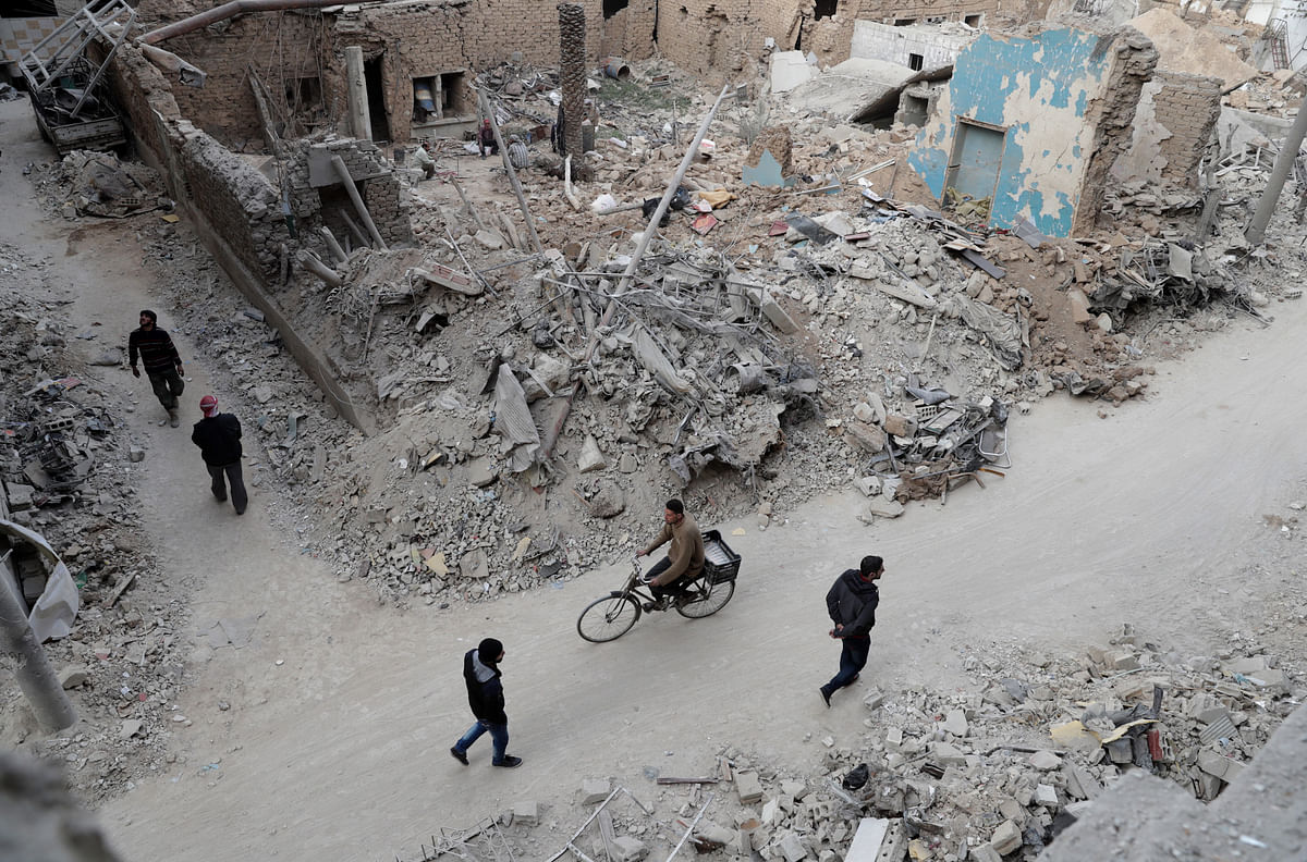 Syrians walk past the rubble of destroyed buildings in the rebel-held town of Douma that witnessed government raids for continue despite the United Nations confirmation a few days earlier that Moscow formally asked its ally Damascus to stop launching strikes during the Geneva negotiations, which began earlier in the week. Photo: AFP