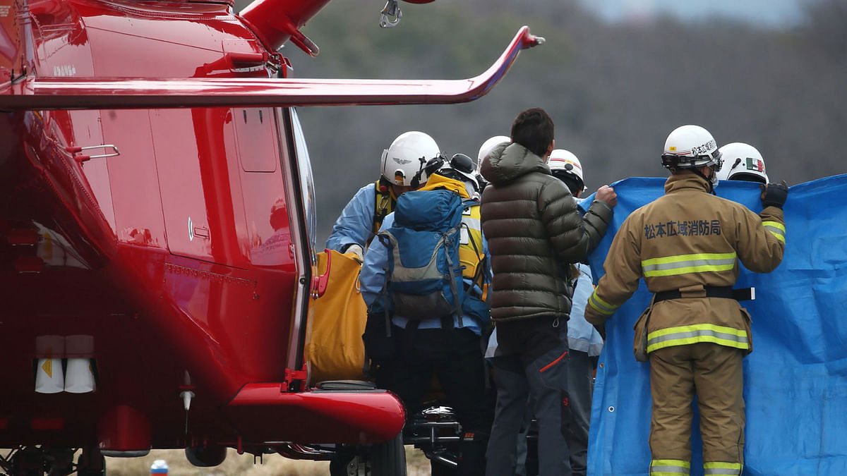 Firefighters transfer a crew from a fallen disaster prevention helicopter in Matsumoto, Nagano prefecture. Photo: AFP