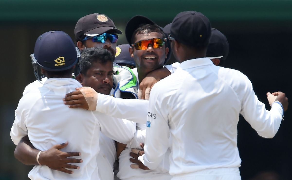 Lankan captain Rangana Herath (2L) celebrates with teammates after the dismissal of Imrul Kayes during final day of the 2nd Test cricket against Bangladesh in Colombo on 19 March 2017. AFP