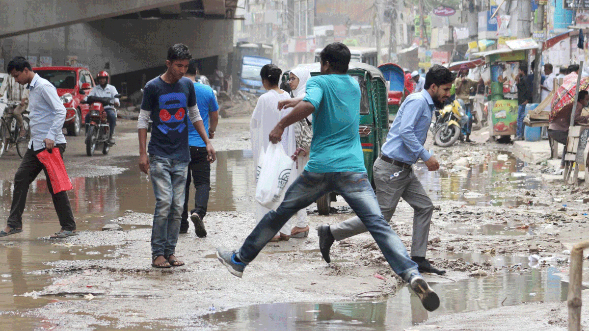 Commuters are seen in Malibagh area after the drizzle in the city on Monday morning. Photo: Focus Bangla