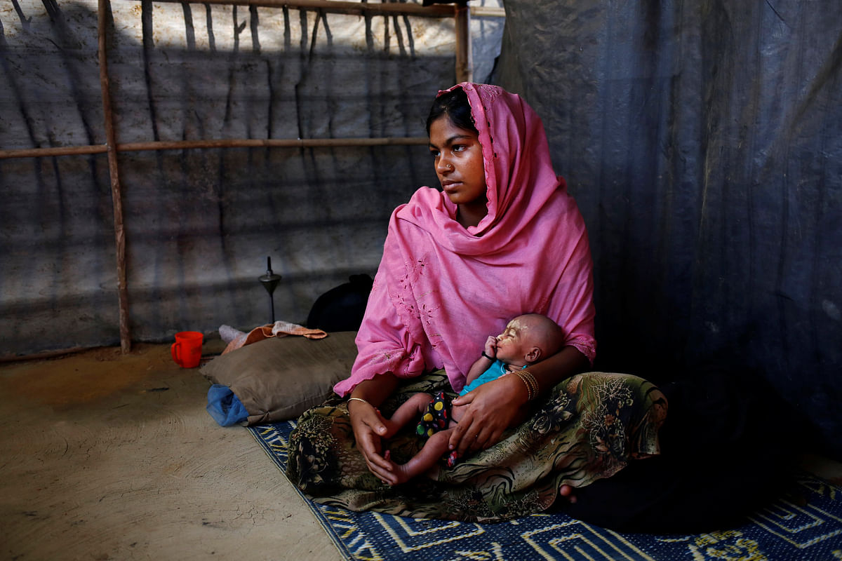 Asmot Ara, 18, holds her seven-day-old unnamed daughter as she poses for a photograph inside their shelter in Balukhali unregistered refugee camp in Cox’s Bazar, Bangladesh, February 8, 2017. Reuters
