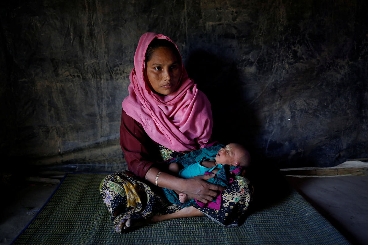 Amina, 30, holds her 16-day-old daughter Sumaiya as she poses for a photograph inside their shelter in Balukhali unregistered refugee camp in Cox’s Bazar, Bangladesh, February 8, 2017. Reuters