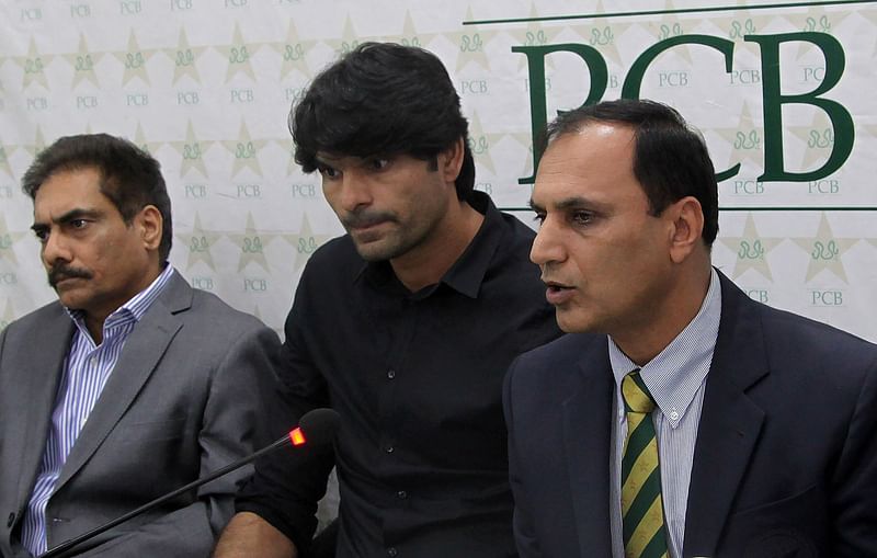 Pakistan Cricket Board (PCB) anti-corruption unit chief Mohammad Azam ® is flanked by suspended cricketer Mohammad Irfan © as he speaks to media in Lahore. Photo: AFP