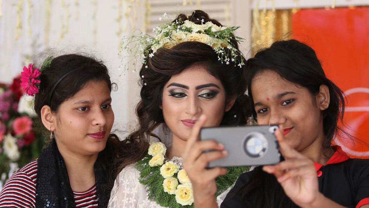Visitors take selfie with a model at flower festival at  Bangla Academy. Photo: Abdus Salam