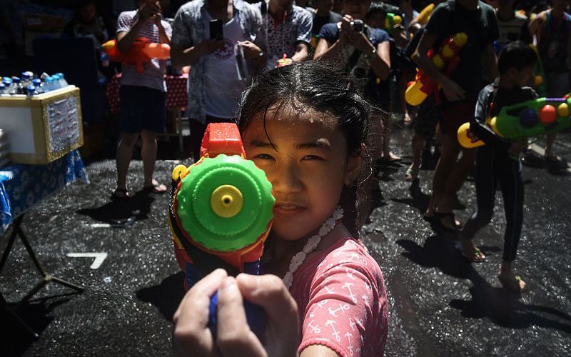 A girl aims a water pistol at the camera during Songkran, Thailand`s traditional New Year festival, on Silom road in Bangkok on April 13, 2017.Photo: AFP