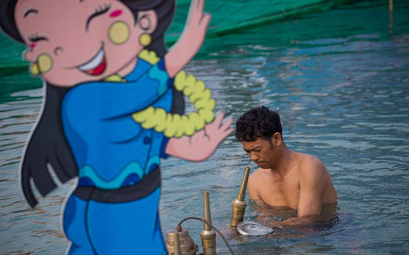 A worker inspects a water jet at a fountain in a park in central Yangon on April 12, 2017, on the eve of the water festival known as Thingyan.Photo: AFP