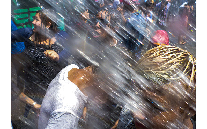 People dance to blasting DJ house music under the spray of water hoses in a street of Yangon on April 13, 2017 while celebrating the Buddhist New Year or Thingyan as it is known locally.Photo: AFP