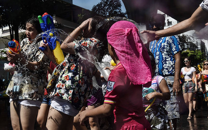 A boy splashes people with cold water during Songkran, Thailand`s traditional New Year festival, on Silom road in Bangkok on April 13, 2017.Photo: AFP