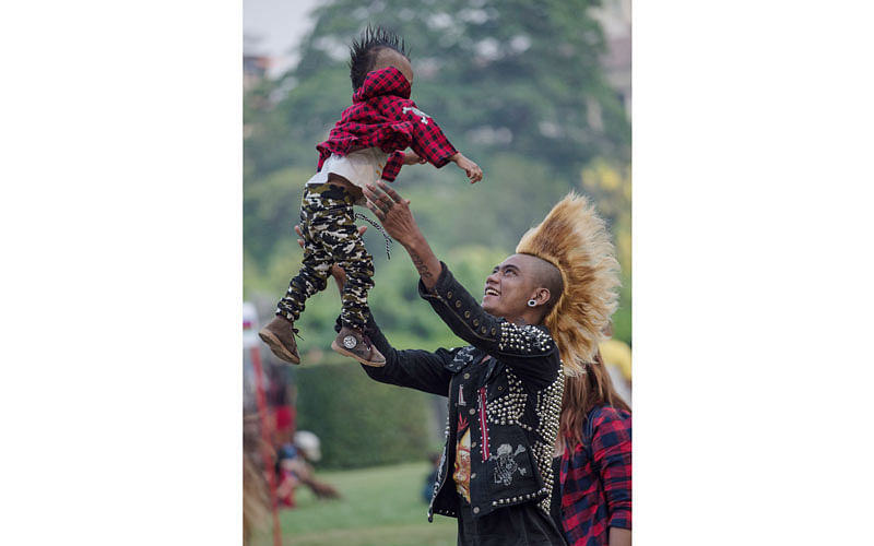 A member of a punk group plays with his one-year-old son as he and some of his friends gather in a park in central Yangon on April 12, 2017, on the eve of the water festival known as Thingyan.Photo: AFP