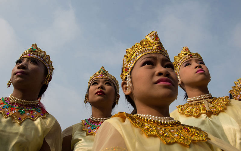 Girls dressed in traditional Bagan dresses watch others dance on a stage at City Hall marking the beginning of the Buddhist New Year or `Thingyan` as it is known locally on April 13, 2017 in Yangon. Photo: AFP
