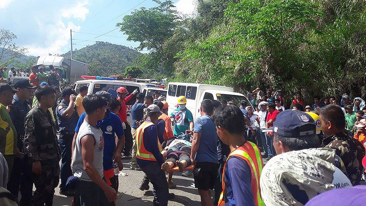 Rescuers carrying a rescue stretcher with one of victims after a passenger bus plunged into a ravine in Carranglan town, Nueva Ecija province, north of Manila. Photo: AFP