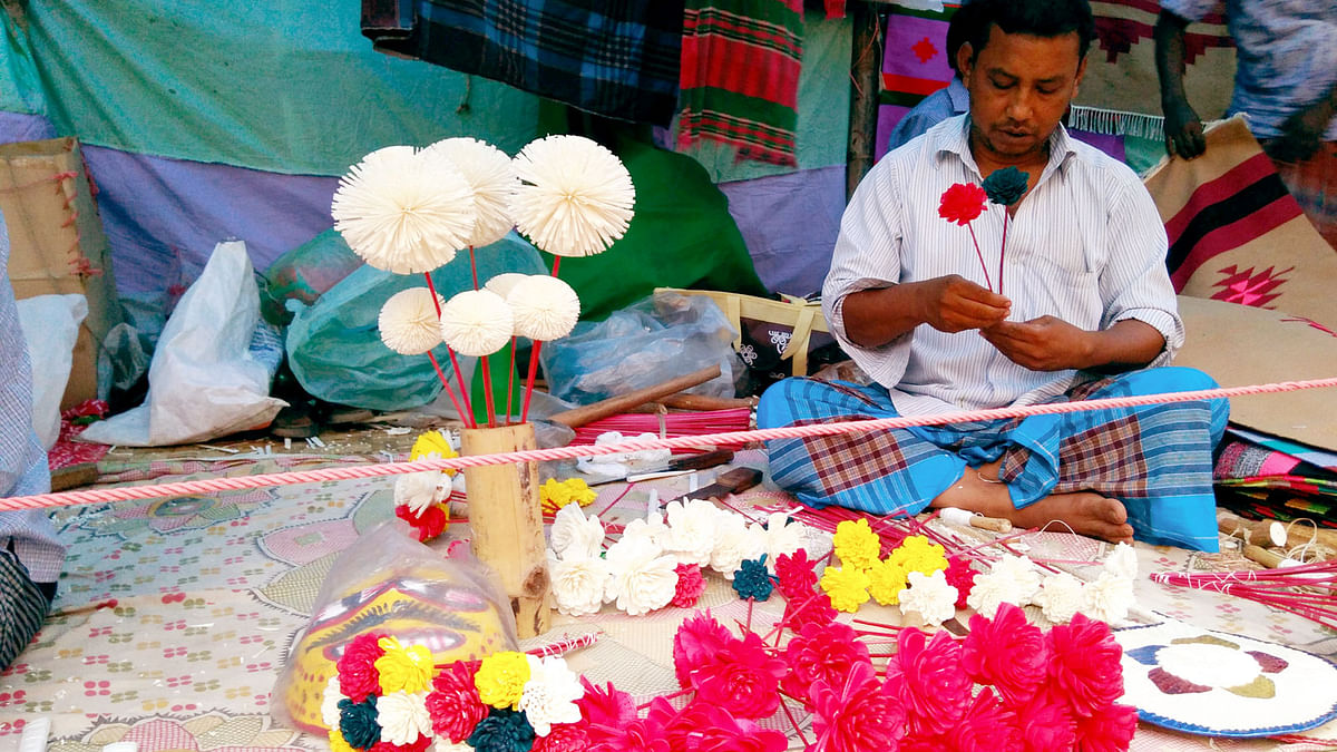 An artiste is making a bouquet at a shop during a fair, `Baishakhi Mela`, on Bangla Academy premises on Saturday. Photo: Toriqul Islam