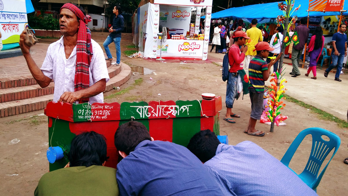 Abdul Jalil Mandal displays `Bayoskop`, during the fair on Bangla Academy premises on Saturday. Photo: Toriqul Islam