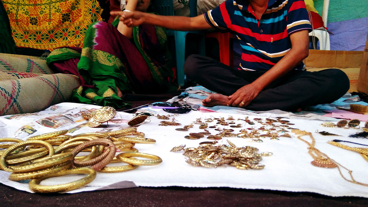 Shopkeeper puts bangles on a display at a shop during a fair, `Baishakhi Mela`, on Bangla Academy premises on Saturday. Photo: Toriqul Islam