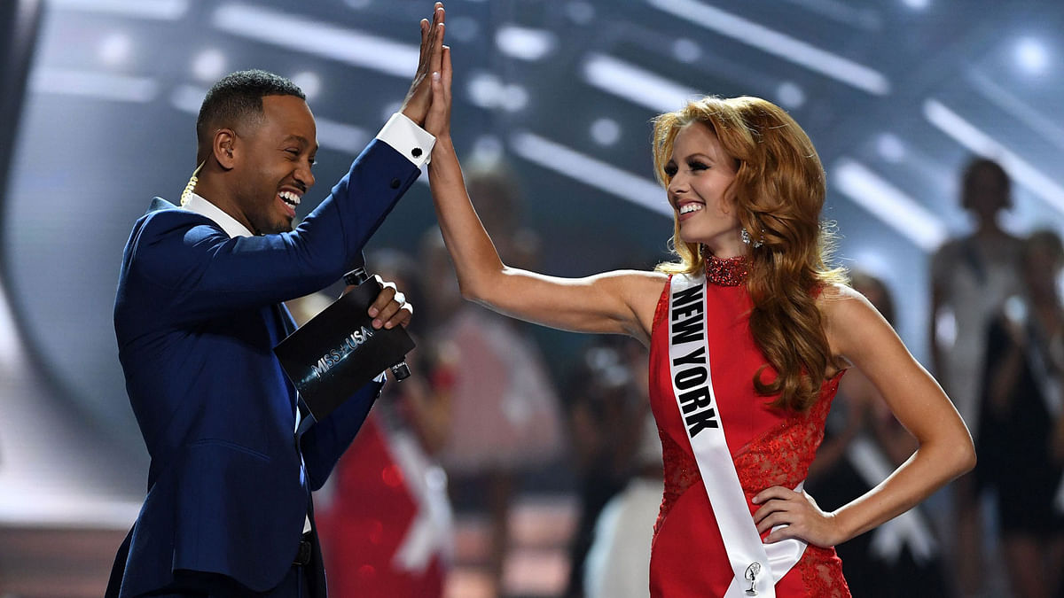 Co-host Terrence J (L) high-fives Miss New York USA 2017 Hannah Lopa after she was named a top 10 finalist during the 2017 Miss USA pageant at the Mandalay Bay Events Center on May 14, 2017 in Las Vegas, Nevada. Photo: AFP