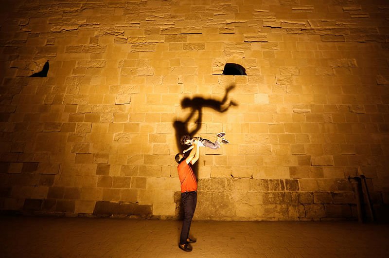 A man plays with his son as light shines on the wall of a maritime museum at the Citadel of Qaitbay on the Mediterranean sea, Alexandria, Egypt June 5, 2017. Reuters