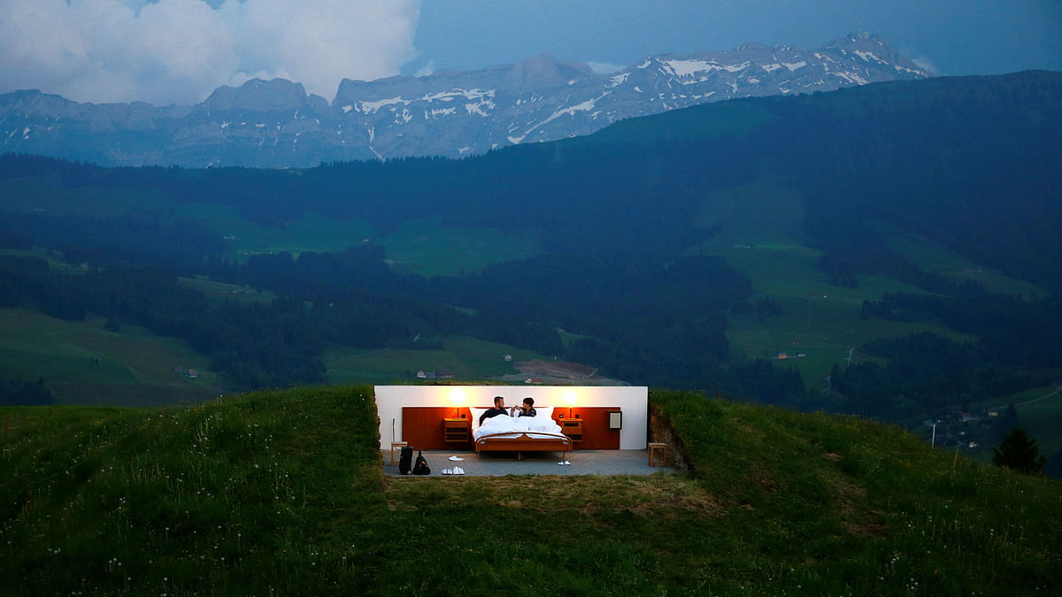 Raphael and Mirjam pose as first guests in the bedroom of the Null-Stern-Hotel land art installation by Swiss artists Frank and Patrik Riklin near Gonten. Reuters
