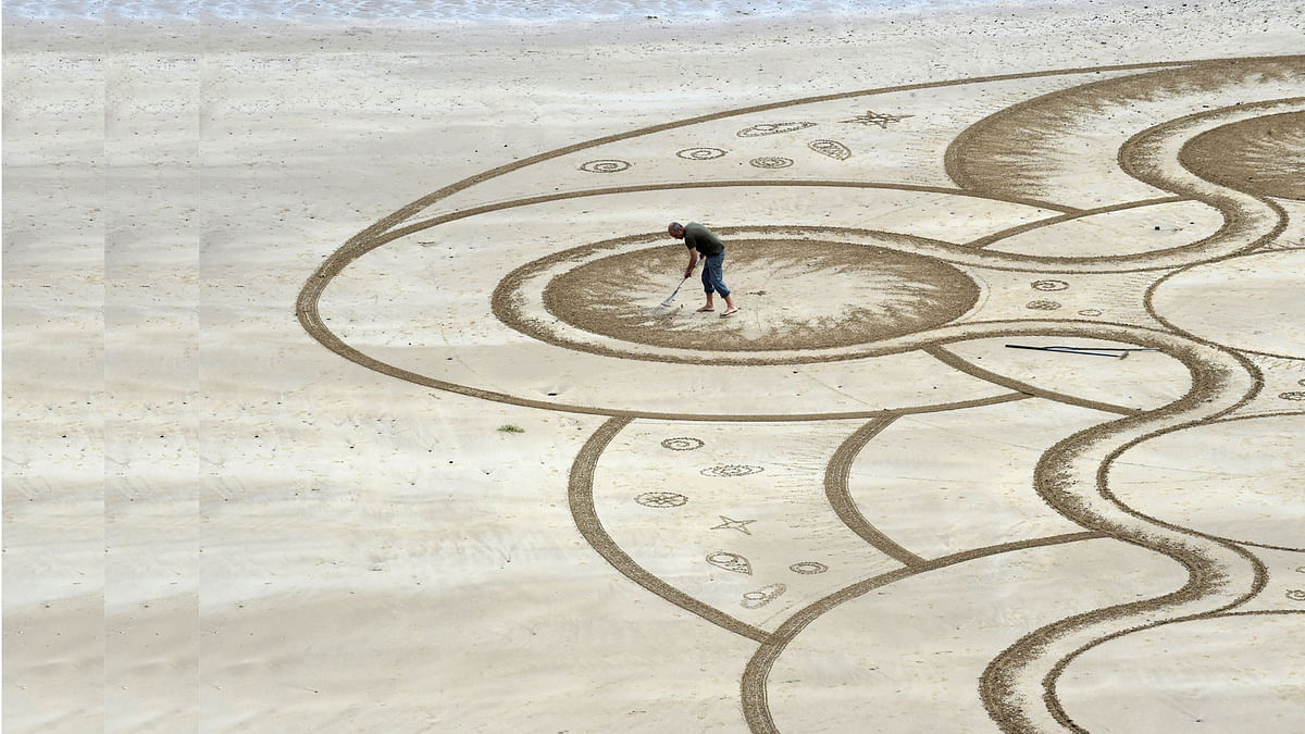 Sand artist Marc Treanor creates a work on the North Beach at Tenby Harbour, Pembrokeshire, Wales, Britain June 7, 2017. Reuters