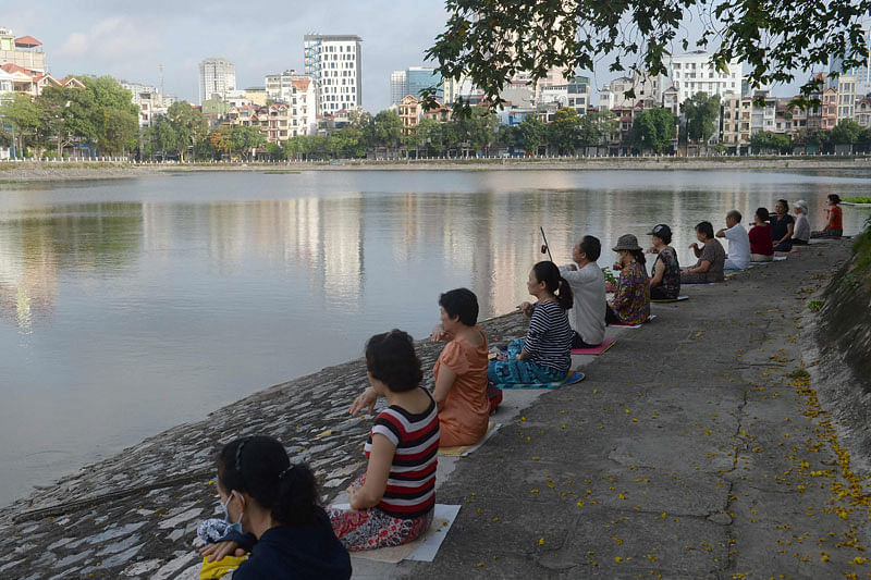 This picture taken on June 10, 2017 shows residents practicing Falun Gong meditation exercises next to a lake in downtown Hanoi. AFP
