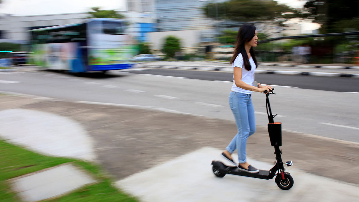 A woman rides a Neuron rental electric scooter in Singapore. Reuters