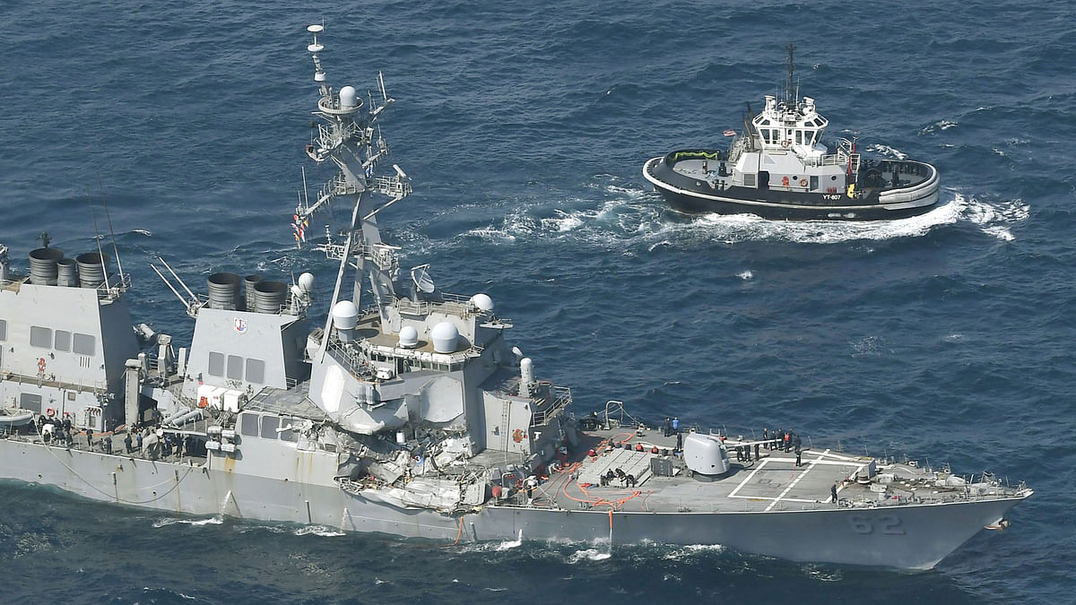 The Arleigh Burke-class guided-missile destroyer USS Fitzgerald, damaged by colliding with a Philippine-flagged merchant vessel, is seen next to a tugboat (R) off Shimoda, Japan in this photo taken by Kyodo 17 June, 2017. Reuters