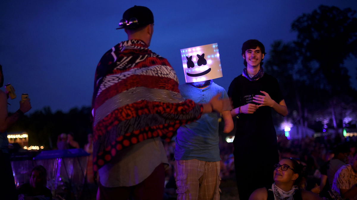 Kevin Wolymetz, 15, wears a smiley face mask during the Firefly Music Festival in Dover, Delaware, U.S. June 16, 2017. Reuters