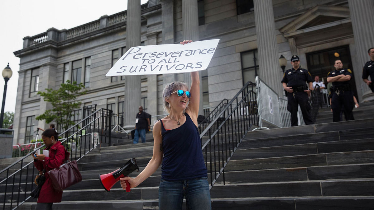 Women`s rights activist Bird Milliken carries a sign outside the Montgomery County Courthouse on 17 June, 2017 in Norristown, Pennsylvania. Photo: AFP