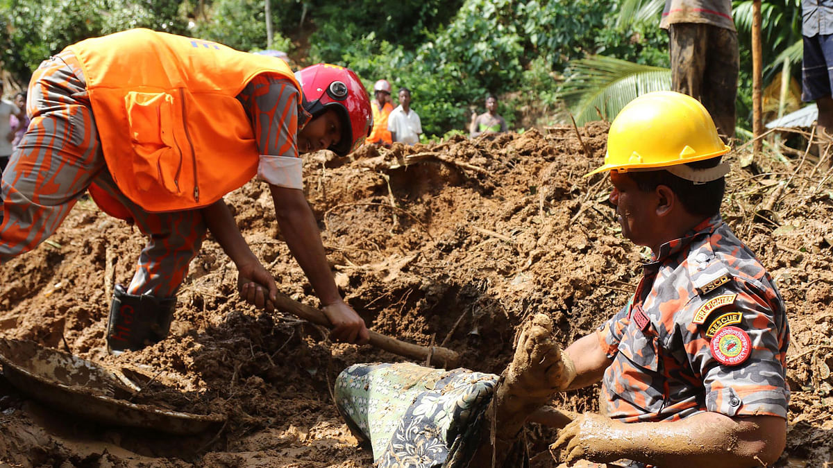 Bangladeshi firefighters try to recover a dead body after a landslide in Rangamati on 14 June, 2017. Photo: AFP