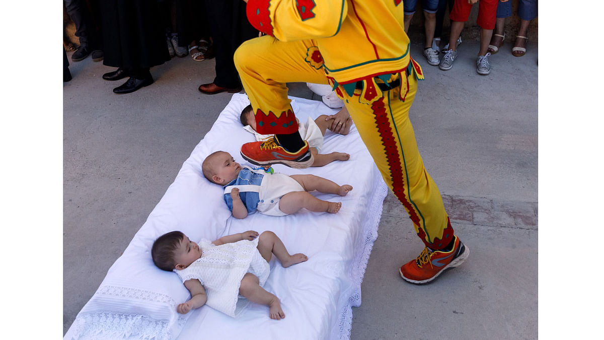 A man dressed up as the devil jumps over babies lying on a mattress in the street during `El Colacho`, the `baby jumping festival` in the village of Castrillo de Murcia, near Burgos on June 18, 2017. AFP