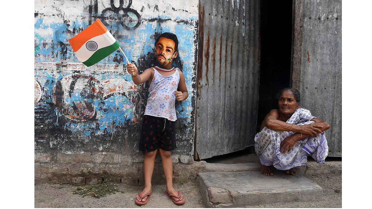 A young Indian cricket fan wears a mask of the face of India`s captain Virat Kohli in Kolkata on June 18, 2017, to mark the Champions Trophy final between India and Pakistan taking place at The Oval in London. AFP