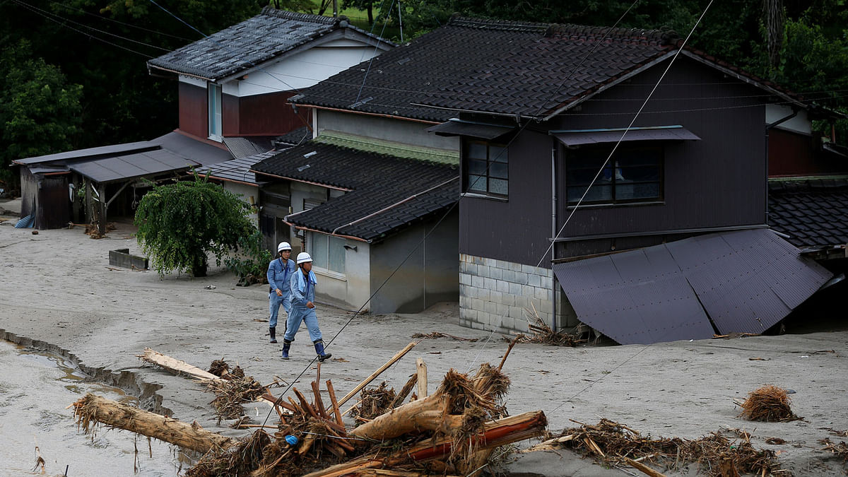 Men walk in front of damaged houses surrounded by swept away after heavy rain in Asakura, Fukuoka Prefecture, Japan. Reuters